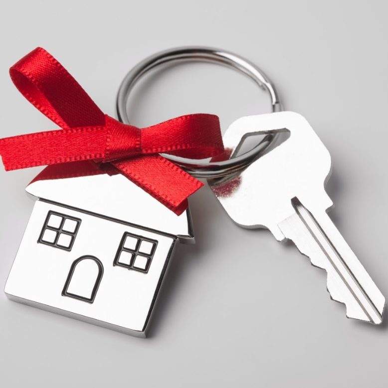 house-keys-with-red-ribbon-on-light-background-picture-id614055202